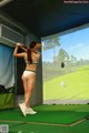 A woman in a bikini swinging a golf club.