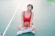 A woman sitting on a basketball court holding a basketball.