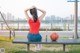 A woman sitting on a bench with a basketball in front of her.