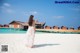 A woman in a white dress standing on a beach.